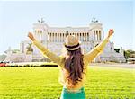 Young woman on piazza venezia in rome, italy rejoicing. rear view