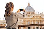 Young woman taking photo of basilica di san pietro in vatican city state