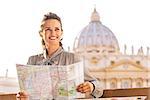 Happy young woman with map on piazza san pietro in vatican city state