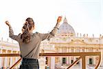 Young woman rejoicing in front of basilica di san pietro in vatican city state
