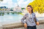 Portrait of happy young woman on bridge ponte umberto I with view on basilica di san pietro