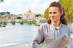 Happy young woman with map on bridge ponte umberto I with view on basilica di san pietro