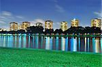 A lagoon at East Coast Park, Singapore, with green pasture in foreground colourful light reflections by night