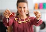 Closeup on young housewife showing mushrooms on string