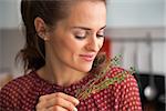 Portrait of young housewife enjoying fresh thymus