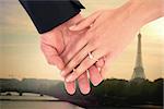 Close-up of bride and groom with hands together against eiffel tower