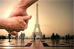 Elderly couple holding hands against eiffel tower