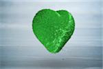 Green heart against bleached wooden planks background