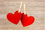 Hearts hanging on line against wooden surface with planks