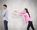 Woman trying to hug man against weathered surface