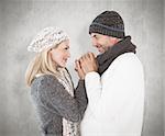 Couple in winter fashion embracing against weathered surface