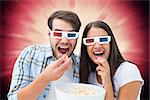 Attractive young couple watching a 3d movie against valentines heart design
