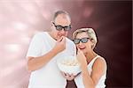 Mature couple wearing 3d glasses eating popcorn against valentines heart design