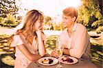 Cute couple having champagne and desert in the park on a sunny day