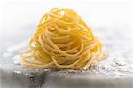 Nest of fresh linguine on a floured marble surface