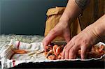 A chef filling a paper bag with cooked prawns