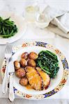 Roast piglet with potatoes and spinach