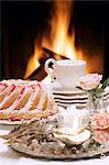 A Bundt cake and a cappuccino in front of an open fire