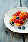 A fruit platter with apricots, blueberries and redcurrants