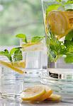 Lemon water with mint in two glasses and a jug