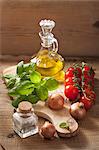 An arrangement of onions, tomatoes, spices, basil and olive oil