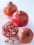 Three whole pomegranates and a halved one