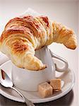 A croissant on top of a coffee cup