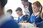 Smiling female teacher with his pupils in classroom