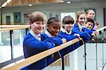 Portrait of elementary school children wearing blue school uniforms standing in school corridor