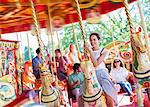 Woman sitting on horse on carousel in amusement park