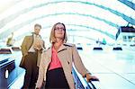 Businesswoman riding escalator