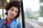 Daydreaming woman looking out train window