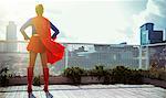 Superhero standing on city rooftop