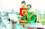 Superheroes working with laptop in office