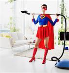 Superhero holding vacuum in living room