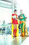 Superheroes working with digital tablet in office