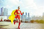 Superhero running on city rooftop