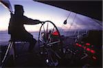Captain helms Endeavour at Dawn towards Antigua with Navigational Instruments Glowing Red