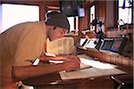 Man makes Entry into Log Book aboard Schooner, Tree of Life