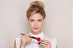 Beautiful woman holding make-up brush