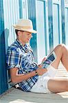 Teenager reading holiday beach summer straw hat