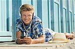 Teenager lying on front beach listening music