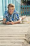Teenager lying on front beach listening music
