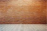 empty room with red brick wall and wooden floor