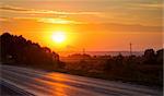 Orange sunset over asphalt road. Horisontal photo