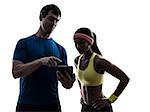 one woman exercising fitness workout with man coach using digital tablet in silhouette on white background