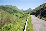 landscape rural grey lonely road between green mountains in countryside of Asturias Spain Europe