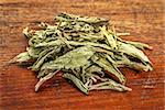 pile of stevia dried leaves against grunge wood -  natural sweetener, sugar substitute