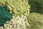 background of five healthy green dietary supplement powders (spirulina, chlorella, wheatgrass, kelp and moringa leaf)