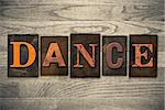 The word "DANCE" written in wooden letterpress type.
